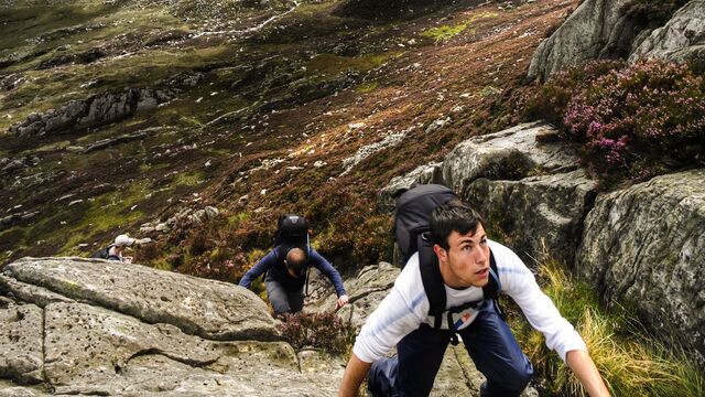 Personal finances - Two man hiking among rocks outdoors - small